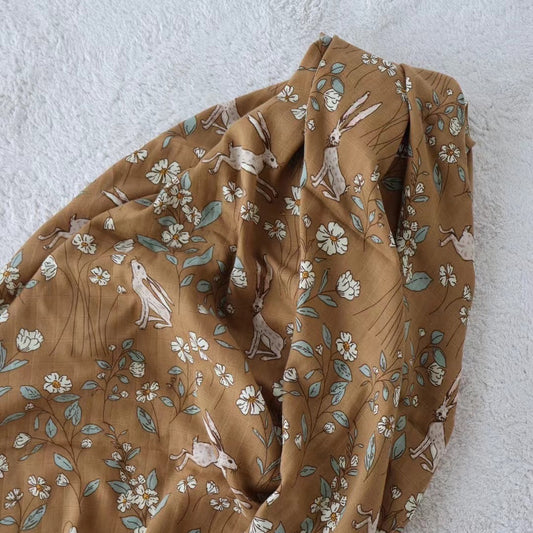 Brown fabric with animal and floral pattern on a light gray background